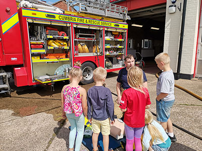 Firefighter talking to a group of children